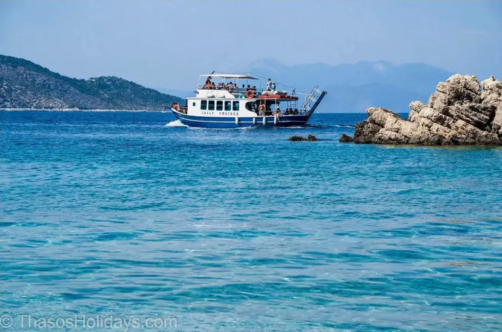 Boat Trip in Greece with boat in the middle of the bay and land in front